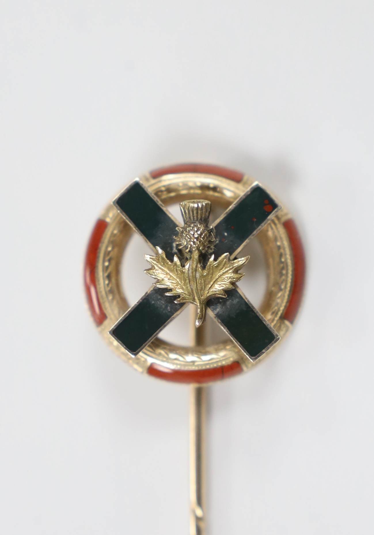 An early 20th century yellow metal and Scottish hardstone set stick pin, with St Andrew's cross and thistle, 8cm overall